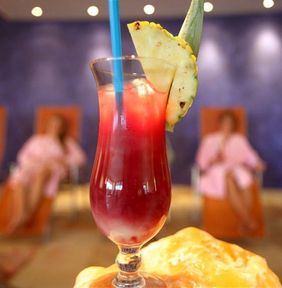 Rot-gelber Cocktail mit Ananas und blauen Strohhalmen in der Gastronomie im Freizeitbad LA OLA